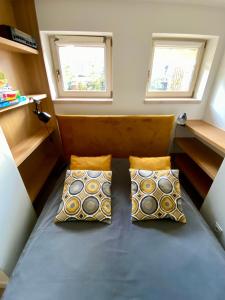 a bed in a small room with two pillows at Sopocki apartament i taras in Sopot