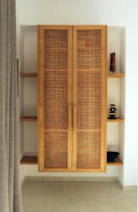 a wooden cabinet with three glass doors at Calistus Mykonos in Mikonos