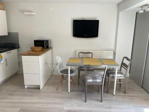 a table and chairs in a kitchen with a tv on the wall at Sopocki apartament i taras in Sopot