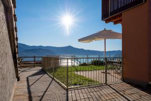 einen Balkon mit Sonnenschirm und Meerblick in der Unterkunft Dali' in Parzanica
