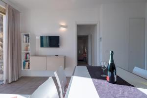 Parzanica的住宿－Dali'，白色的客厅,桌子上放着一瓶葡萄酒