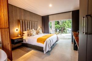a bedroom with a bed and a large window at Beach Wood Boutique Hotel & Resort in Ballito