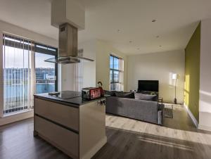a kitchen and living room with a couch at Bankside by Wycombe Apartments in High Wycombe