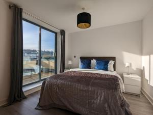 a bedroom with a bed and a large window at Bankside by Wycombe Apartments in High Wycombe