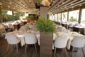 a dining room with white tables and white chairs at Istanbul Park Hotel in Tuzla