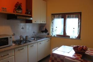 a kitchen with a sink and a table with a microwave at La Madonnina in Villa di Tirano