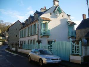 un'auto parcheggiata di fronte a una casa di Chambres Chez Mounie ad Arromanches-les-Bains