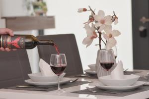 une personne versant du vin rouge dans un verre sur une table dans l'établissement WINETIME - modern - für 5 - idyllisch - Netflix, à Roschbach