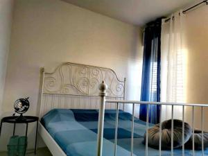 een slaapkamer met een bed met blauwe lakens en een raam bij Apartman Mela in Orebić