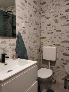 een badkamer met een wit toilet en een wastafel bij Apartman Mela in Orebić