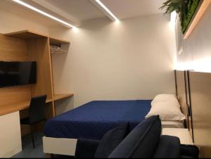 1 dormitorio con 1 cama, TV y silla en B&B Del Corso, en Scafati