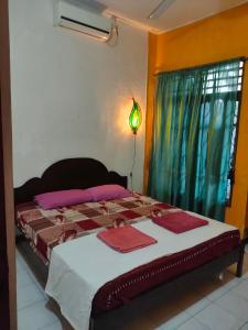 um quarto com uma cama grande com janela em Casa Minha Backpackers Hostel em Dili