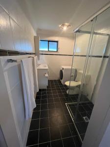 a bathroom with a toilet and a shower at The Entrance & Shelly Beach Holiday House in Long Jetty