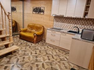 - une cuisine avec un fauteuil en cuir et un évier dans l'établissement Apartamentai Renata, à Druskininkai