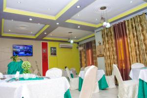 un salón de banquetes con mesas blancas y sillas blancas en Appartement de 3 chambres avec balcon et wifi a KinshasaELv en Kinshasa