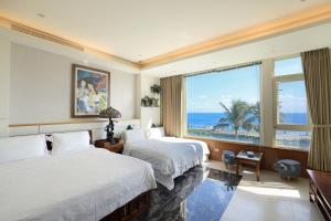 ein Hotelzimmer mit 2 Betten und einem großen Fenster in der Unterkunft View Ocean in Hualien