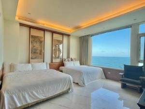 two beds in a room with a view of the ocean at View Ocean in Hualien City