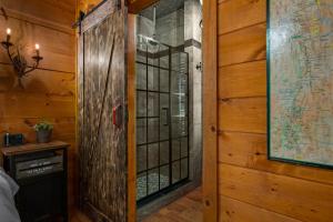 una camera con una porta di vetro in una parete di legno di Dreamy Cabin & Outdoor Oasis! Mins to Nat'l Park! a Townsend