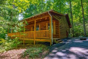 a cabin in the woods with a wrap around porch at Dreamy Cabin & Outdoor Oasis! Mins to Nat'l Park! in Townsend