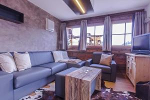 een woonkamer met een blauwe bank en een tv bij Appartamenti Residence Pars in Badia