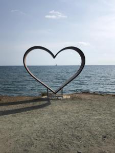 a heart sculpture on a beach near the ocean at Mazotos Panoramic Village in Mazotos