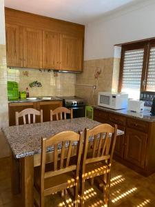 cocina con mesa con sillas y encimera en Casa dos Avós, en Alvares