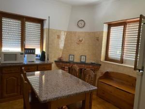 Alvares的住宿－Casa dos Avós，厨房配有桌椅和墙上的时钟
