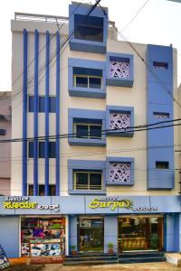 a building with a store in front of it at Hotel Surya Lodge in Mysore