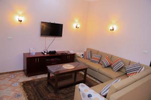 sala de estar con sofá y TV en Tomorrow Land villa, en Luxor