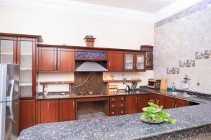 a large kitchen with wooden cabinets and a counter top at Tomorrow Land villa in Luxor