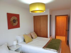 um quarto com uma cama branca e uma luz amarela em Welcome Here Parque Lumiar 1 em Lisboa