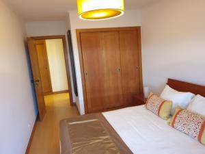 um quarto com uma cama e uma porta de madeira em Welcome Here Parque Lumiar 1 em Lisboa
