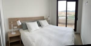 une chambre avec un grand lit blanc et une fenêtre dans l'établissement Casa Paraiso, à Carthagène 19 autres photos