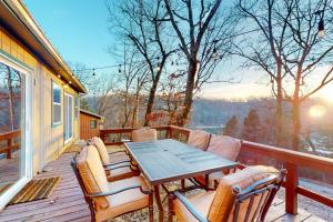 a wooden deck with a table and chairs on it at Ozark Rambler Cabin in Eureka Springs