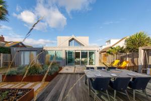 a house with a table and chairs on a patio at Insta-worthy 4br designer house 5 min to the beach in West Wittering