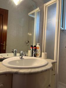 uma casa de banho com um lavatório e um espelho em Habitación cómoda a 10 minutos del centro em Pamplona