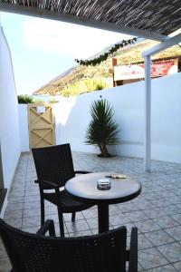 d'une terrasse avec une table, deux chaises et une table. dans l'établissement Stromboli Central Family Apartment - 3 Double Rooms, à Stromboli