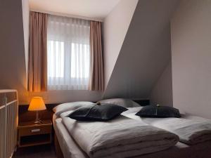 ジンデルフィンゲンにあるT24 - Ihr Appartement mit Charakterのベッドルーム1室(ベッド2台、窓付)