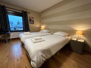 two twin beds in a room with a window at Race & Rooms in Francorchamps