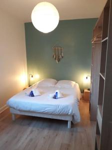 a bedroom with a large white bed with a light at Stella maris in Carnac