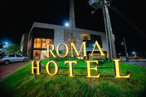 um sinal de néon que diz roma hotel em frente a um edifício em Roma Hotel em Bacabal