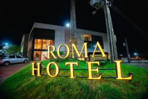 a neon sign that says roma hotel in front of a building at Roma Hotel in Bacabal