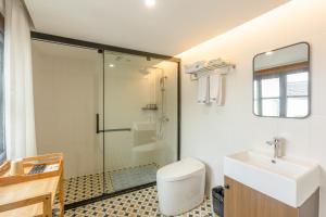 een badkamer met een douche, een toilet en een wastafel bij Tongli 1917 Best South Inn in Suzhou