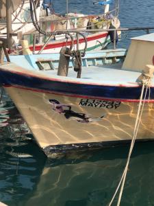 a boat tied to a dock in the water at Mazotos Panoramic Village in Mazotos