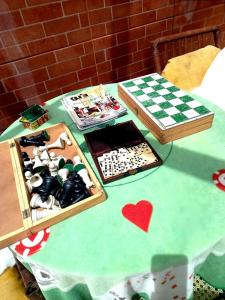 una mesa con un tablero de ajedrez y otros elementos en Casarão Refugio da Serra Suites,4km do Baden Baden, en Campos do Jordão