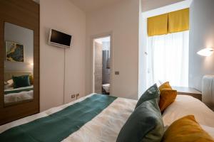 a bedroom with a bed and a tv on the wall at Hotel Continental in Senigallia