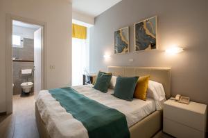 una camera da letto con un letto con cuscini verdi e gialli di Hotel Continental a Senigallia