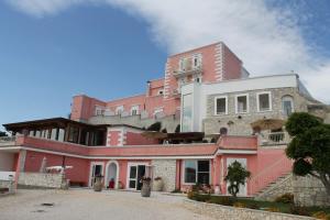 a large pink building sitting on top of a street at Hotel Boutique Il Castellino Relais in Vieste