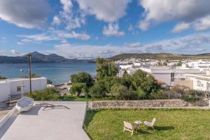 eine Terrasse mit 2 Stühlen und Blick auf das Wasser in der Unterkunft White Villa Milos in Adamas