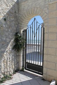 an iron gate with a view of the beach at Hotel Boutique Il Castellino Relais in Vieste